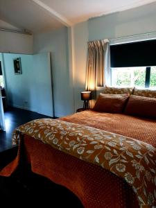 a bedroom with a large bed with a window at Tree View Studio in Tauranga