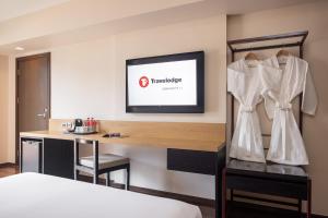 バンコクにあるTravelodge Sukhumvit 11のベッドと机があるホテルの部屋