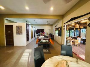 a living room with a table and a dining room at Tropical Langkawi in Pantai Cenang