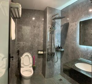 a bathroom with a toilet and a shower and a sink at Jademay Airport Hotel in Sóc Sơn +33 photos