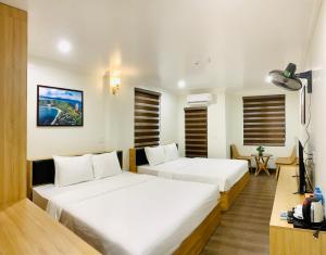 a hotel room with two beds and a television at Jademay Airport Hotel in Sóc Sơn