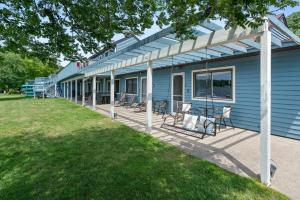 a blue house with chairs sitting on the porch at 5 Lodges Together by Fife Lake - Group Retreat in Fife Lake