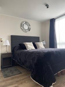 a bedroom with a bed and a mirror on the wall at Vista Laguna Departamento in Concepción