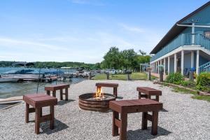 een vuurplaats met banken en tafels naast een gebouw bij 3 Combined Private Lakeside Studios - Upper Level in Fife Lake