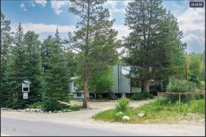 a house sitting on the side of a road with trees at Quaint townhome in downtown Winter Park, Ski and Bikers Paradise, Walk to Town in Winter Park