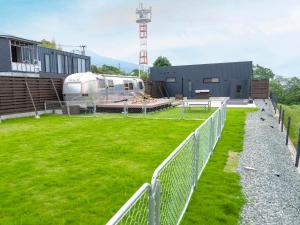 una autocaravana estacionada en un campo al lado de un edificio en FOG villa&spa, en Kirishima