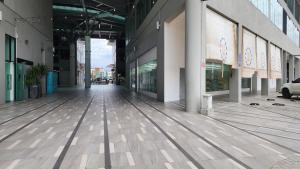 an empty hallway of a building with glass windows at Luxe Loft 3BR Emporium 9pax in Kuching
