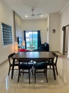 un tavolo da pranzo e sedie in un soggiorno di AYAAN FIFA HOME at Quintet Private Parking a Tanah Rata
