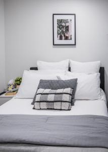 a white bed with a black and white pillow on it at Melbourne Central Gem in Melbourne