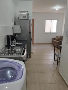 a kitchen with a stove and a refrigerator at Apartamento novo e aconchegante! in Jaboticabal