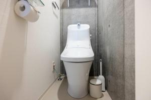 a white toilet in a bathroom with a roll of toilet paper at PASEO Ichigayadaimachi 2 in Tokyo +34 photos