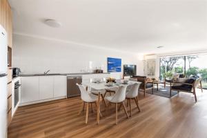 a kitchen and living room with a table and chairs at 2 CapeView Beachfront Geographe Bay in Broadwater +21 photos