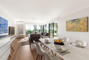 a dining room and living room with a table and chairs at 2 CapeView Beachfront Geographe Bay in Broadwater