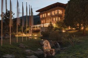 a house with a pond in front of a building at Zhiwaling Heritage in Paro