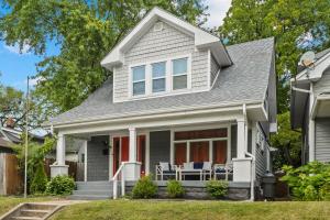 a white house with blue chairs on the porch at OrangeHome in Indianapolis