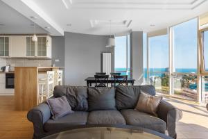 a living room with a couch and a kitchen at Gagarin Plaza Apartment in Odesa