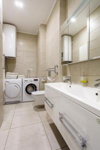 a bathroom with a sink and a washing machine at Gagarin Plaza Apartment in Odesa