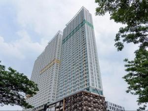 a tall building with a crane in front of it at B residence apartment BSD cozy and nice in Tjilandak