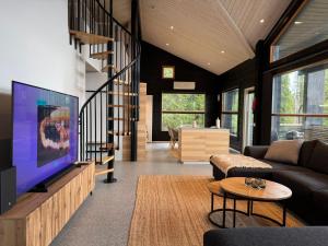 a living room with a large flat screen tv at Villa Ruka - Rising Sun with 3 bedrooms, loft, sauna and balcony with a view in Ruka
