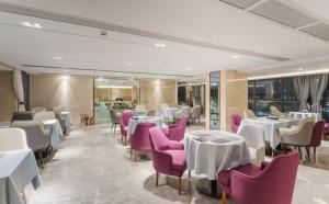 a restaurant with white tables and pink chairs at 麗枫酒店广州番禺汉溪长隆大石地铁站店 in Guangzhou