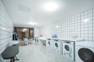 a laundry room with three washing machines and a counter at 麗枫酒店广州番禺汉溪长隆大石地铁站店 in Guangzhou