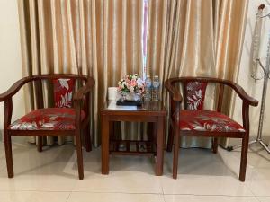two chairs and a table with a vase of flowers at Rose in Hue