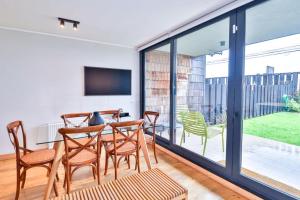 a dining room with a table and chairs and sliding glass doors at HOM I Frente a la Costanera Depto Familiar 3D2B in Puerto Varas +65 photos