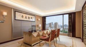 a dining room with a table and a large window at Wuhan Soluxe Hotel in Wuhan