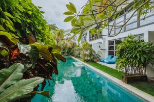 an image of a swimming pool in a house with plants at Berawa Loft by Betterplace in Canggu