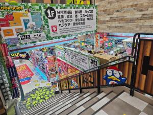 an aisle of a grocery store with an escalator in it at Encounter Ohashi in Fukuoka