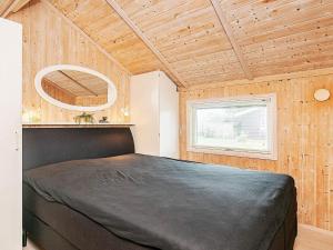 a bedroom with a large bed in a wooden room at 5 person holiday home in Otterup in Otterup