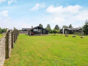 a house in a field with a fence at 5 person holiday home in Otterup in Otterup