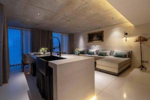 a kitchen and living room with a sink and a couch at Hôtel de Soie in Danang +86 photos