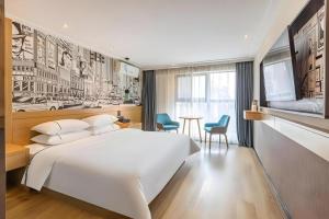 a bedroom with a large white bed and a table at City Comfort Inn Wuhan Dream Times Baotong Temple Metro Station in Wuhan +158 photos