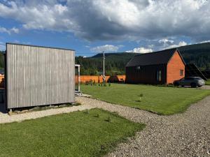 a barn and a car parked next to a house at Barn S&S House in Mykulychyn