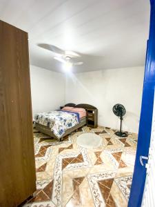 a room with a bed sitting on a tile floor at Casa a 400m do Mar - O endereço correto é o Rua Rubens Marcus Rocha 541 Jd Jamaica Itanhaem in Itanhaém +4 photos