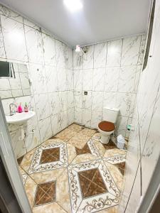 a bathroom with a toilet and a sink at Casa a 400m do Mar - O endereço correto é o Rua Rubens Marcus Rocha 541 Jd Jamaica Itanhaem in Itanhaém