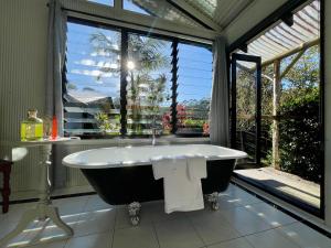 baño con bañera frente a una ventana en Nightcap Ridge - Byron Bay Hinterland, en Dorroughby 68 fotos más