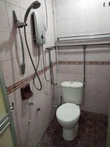 a bathroom with a toilet and a phone on the wall at Sacha Semarak in Baling