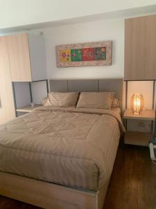a bedroom with a large bed with two night stands at M-town residence cozy apartment gading serpong in Pumpangsineng
