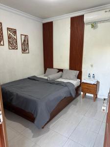 a bedroom with two beds and a table in it at Homestay Joglo Beji in Gading +5 photos