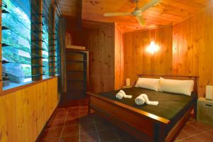 a bedroom with a bed in a wooden room at Daintree Cascades in Cape Tribulation