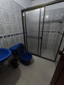 Un baño con inodoro azul y ducha. en Brisas de la Rivera Tauramena, en Tauramena 9 fotos más