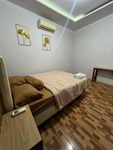 a small bedroom with a bed and a table at Homestay Omah Joglo in Gading +5 photos