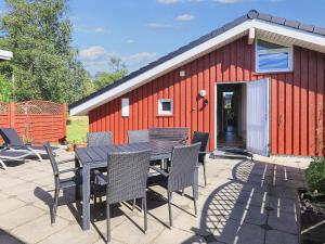 a table and chairs in front of a red building at 4 star holiday home in Hals in Hals