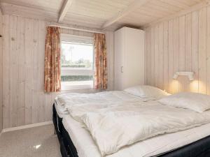 a large bed in a room with a window at 4 star holiday home in Hals in Hals