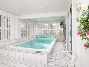 a swimming pool in a white room with a tub at 8 person holiday home in Hals-By Traum in Hals