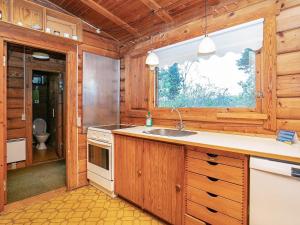 a kitchen with wooden cabinets and a sink and a window at 6 person holiday home in Rudkøbing in Spodsbjerg +19 photos