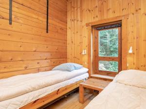 a log cabin with two beds and a window at 6 person holiday home in Rudkøbing in Spodsbjerg