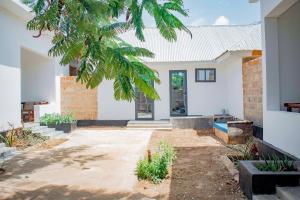 a house with a courtyard with a tree at Miska Zanzibar in Kizimkazi